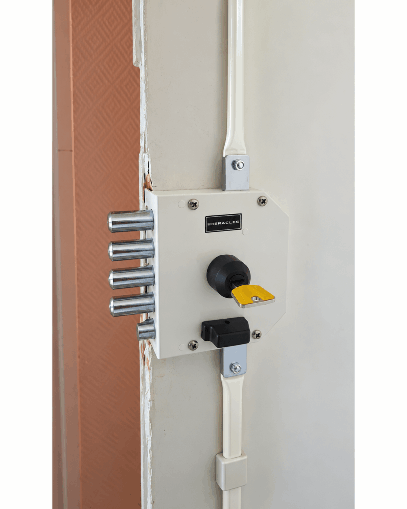 Serrure de sécurité Héraclès en applique avec coffre apparent et pênes de verrouillage sur une porte d'entrée.